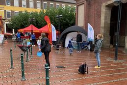 Einige Menschen spielen bei regnerischem Wetter diverse Spiele, wie Discgolf oder Leitergolf.